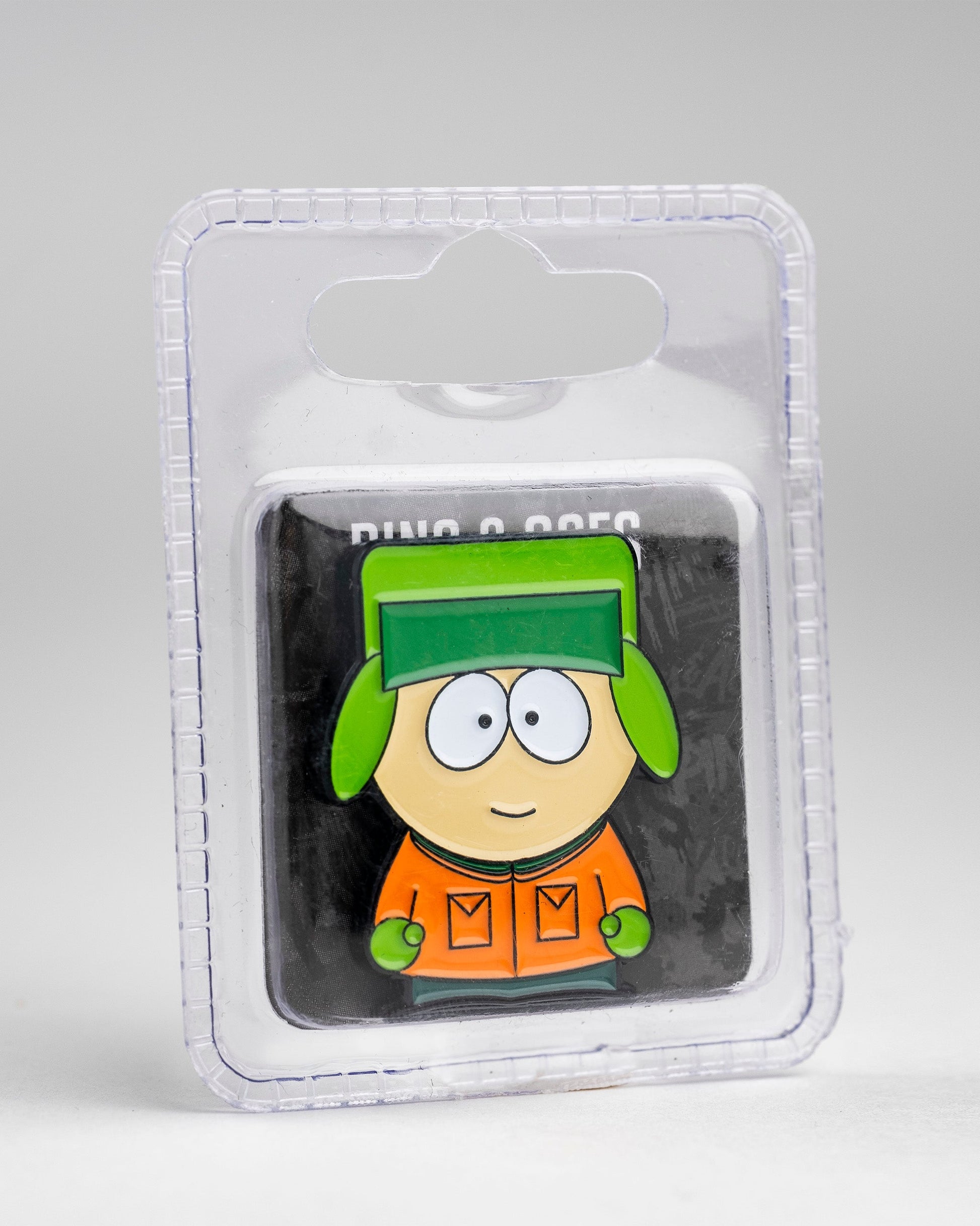 The Pins and Aces South Park Ball Marker - Kyle features a cartoon boy in a green hat and orange jacket, displayed in clear plastic packaging.