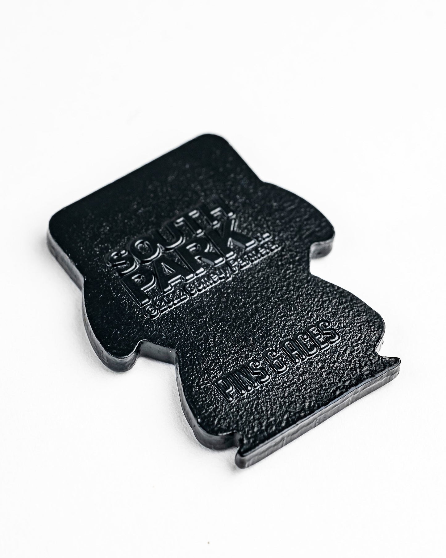 The South Park Ball Marker - Kyle by Pins and Aces is a black, flat, character-shaped ball marker featuring embossed branding, shown on a white background.