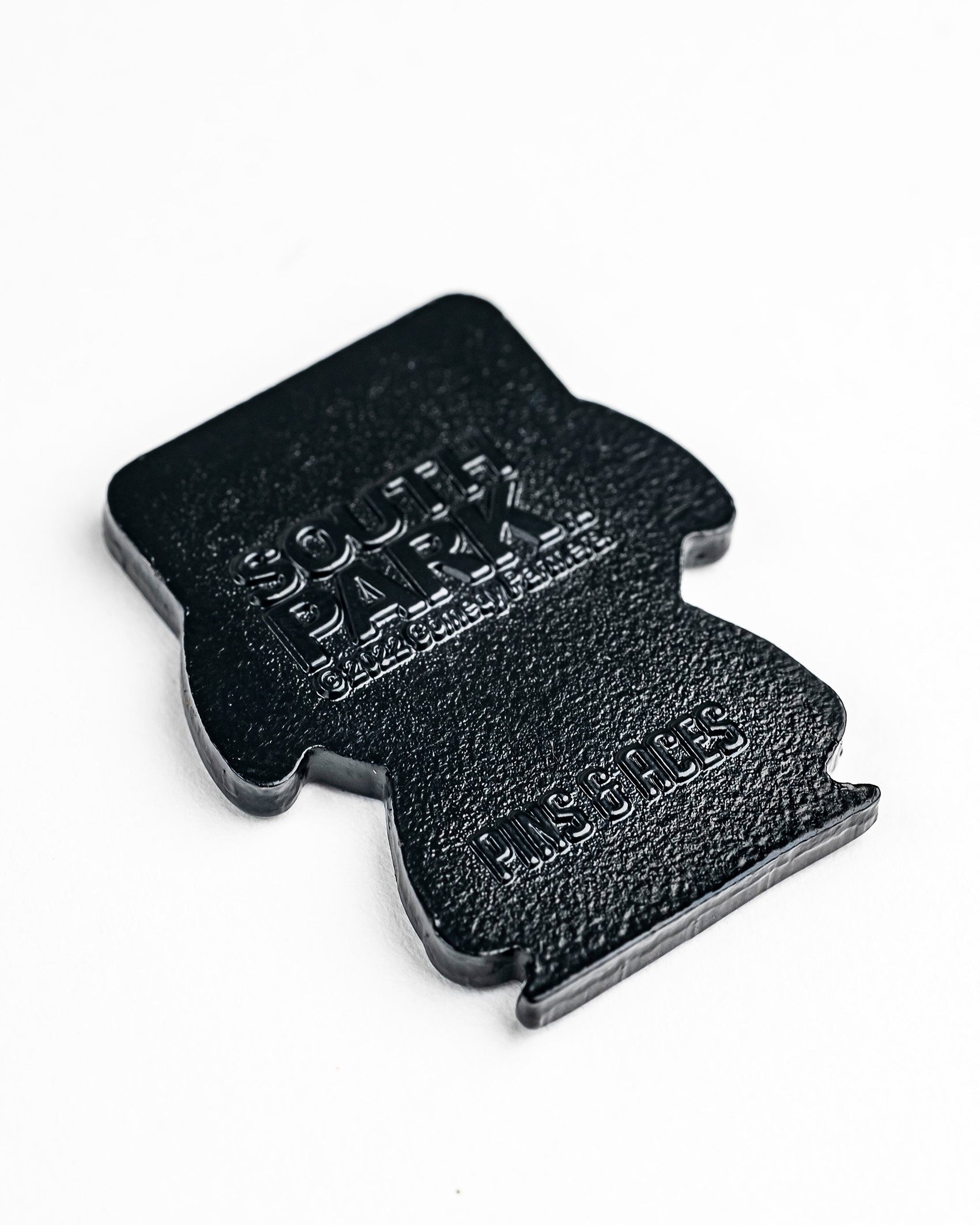 The South Park Ball Marker - Kyle by Pins and Aces is a black, flat, character-shaped ball marker featuring embossed branding, shown on a white background.