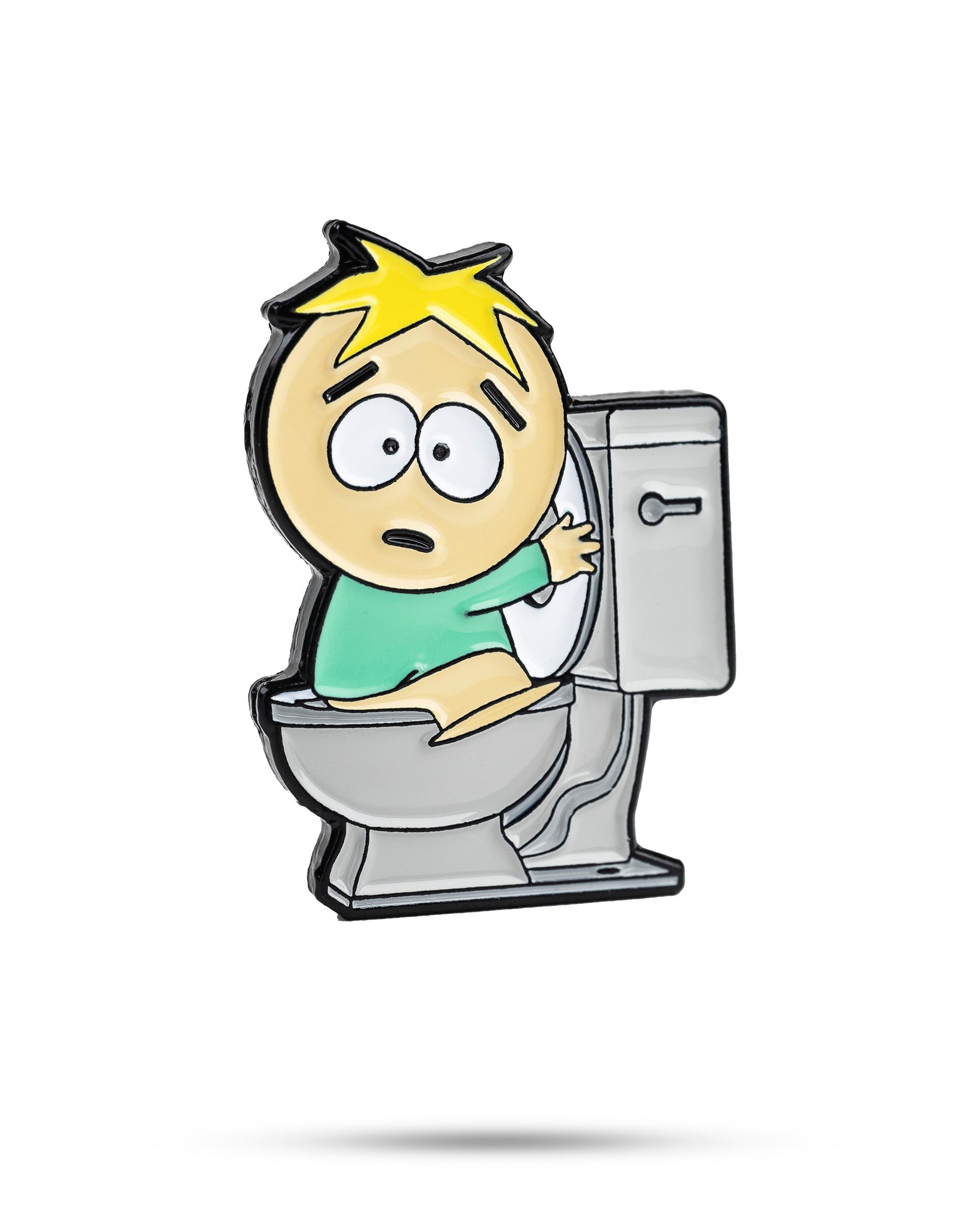 The South Park Ball Marker - Butters by Pins and Aces features a surprised cartoon character with yellow hair and a green shirt sitting on a toilet—ideal for fans of South Park golf gear and premium ball markers.
