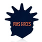 A dark, irregularly shaped stainless steel golf marker by Pins and Aces features “Statue of Liberty” in bold orange at the center. The background is plain white.