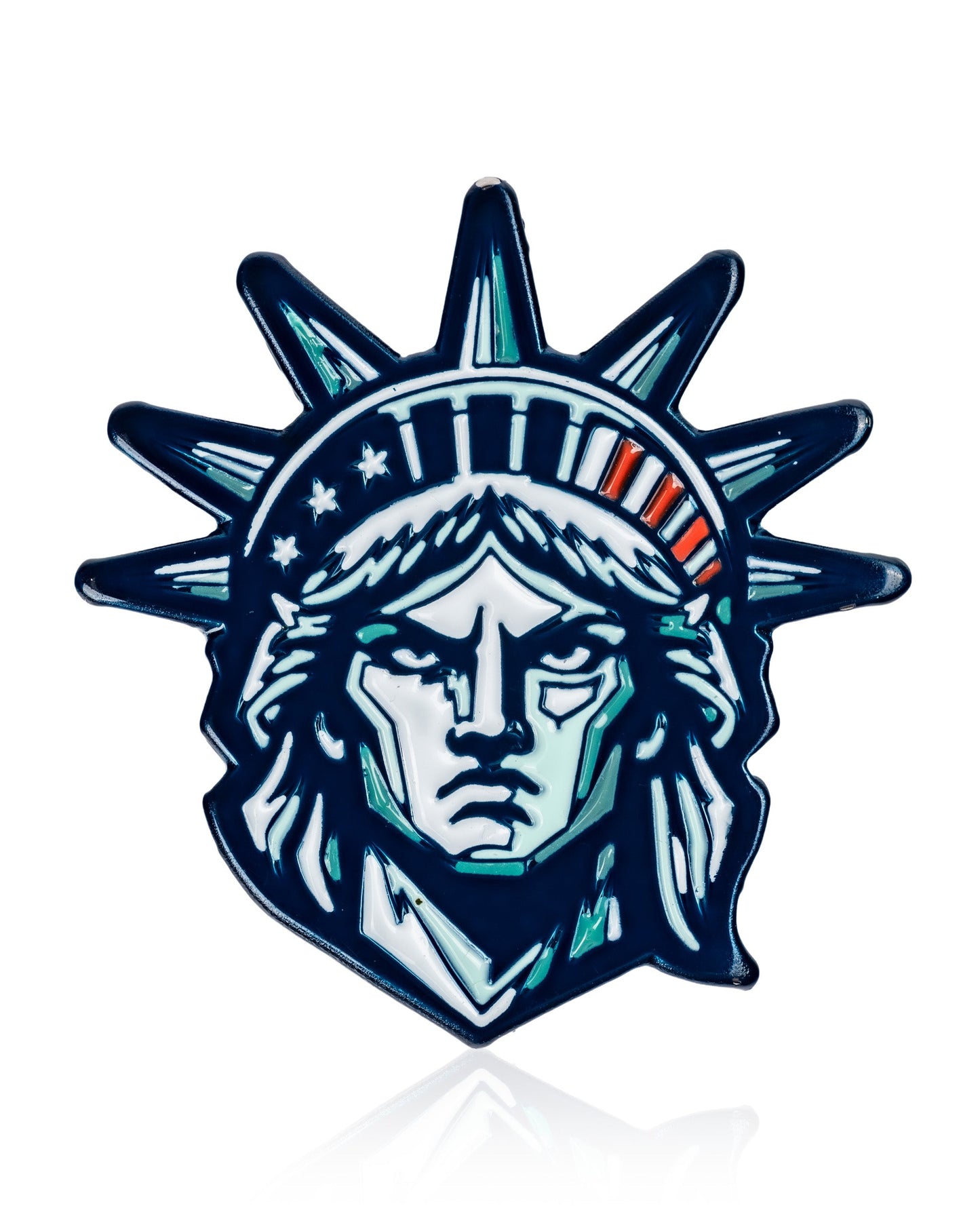 The Pins and Aces Statue of Liberty - Ball Marker features a blue, white, and green stylized illustration of Lady Liberty’s head with her iconic crown, ideal for adding inspiration to your golf game. Set against a clean white background.