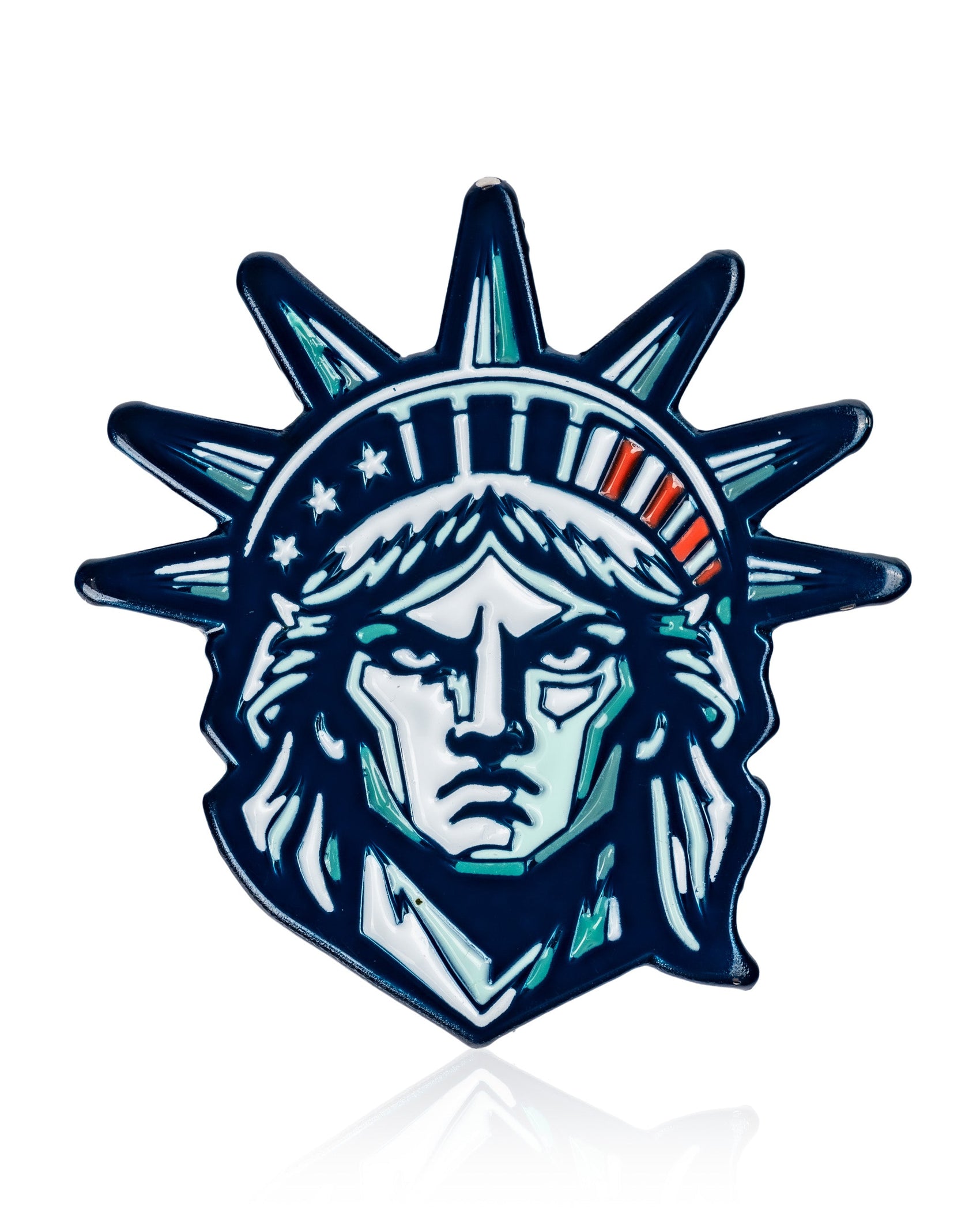 The Pins and Aces Statue of Liberty - Ball Marker features a blue, white, and green stylized illustration of Lady Liberty’s head with her iconic crown, ideal for adding inspiration to your golf game. Set against a clean white background.
