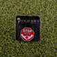A funny golf ball marker on grass features a red stop sign with STOP BEING A above a white hand gesture. The backing card shows Ballmarkers by Logie Joes with a palm tree logo. Product name: Stop Being a P*%#!.