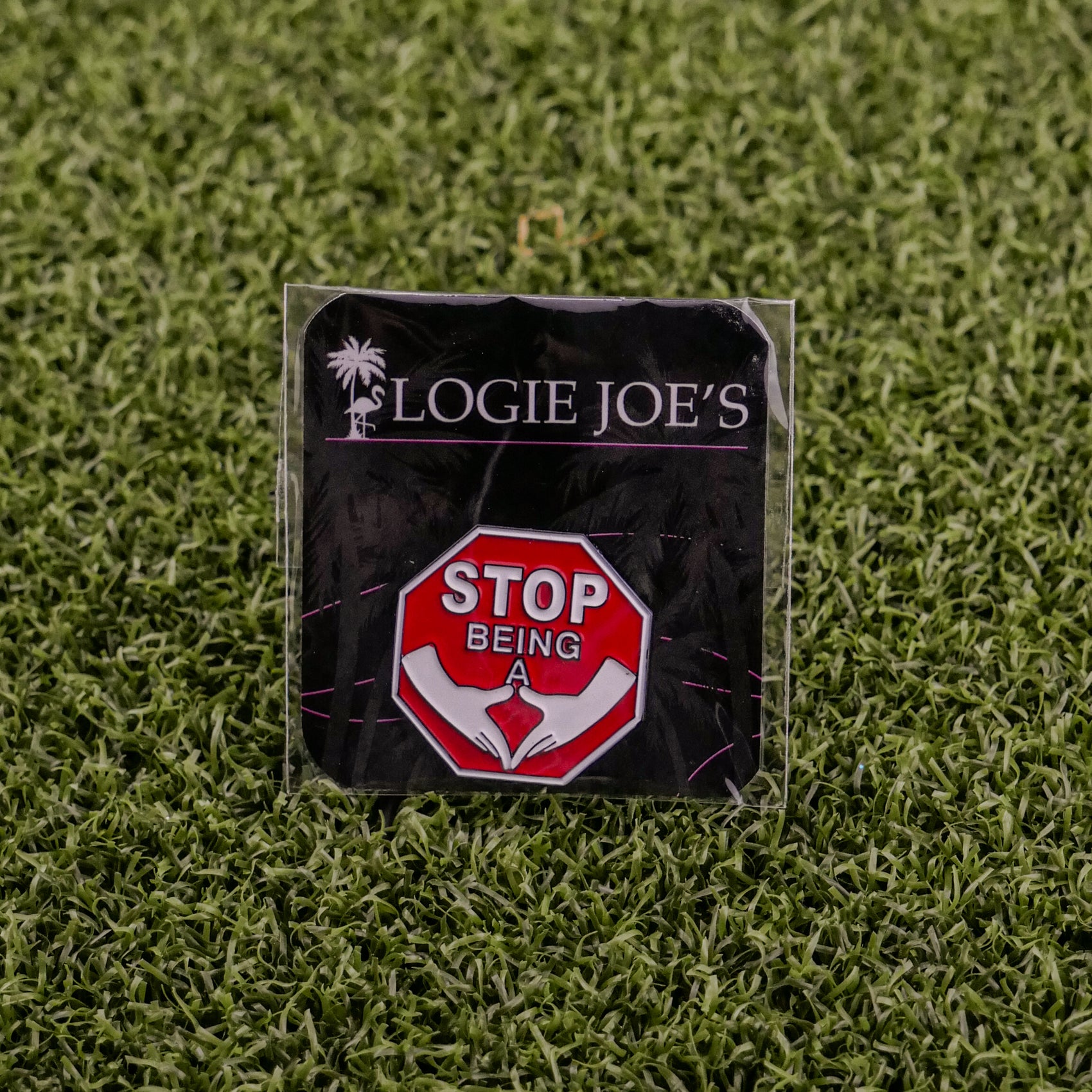 A funny golf ball marker on grass features a red stop sign with STOP BEING A above a white hand gesture. The backing card shows Ballmarkers by Logie Joes with a palm tree logo. Product name: Stop Being a P*%#!.