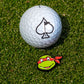 A golf ball rests on green grass beside the Pins and Aces TMNT - Raphael Ball Marker, featuring a cartoon turtle with a red mask—the ideal accessory for Teenage Mutant Ninja Turtles fans.