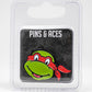 The TMNT - Raphael Ball Marker by Pins and Aces features Raphael’s smiling face, making it a perfect golf accessory. It comes displayed on a black Pins and Aces card and is packaged in a clear plastic case.