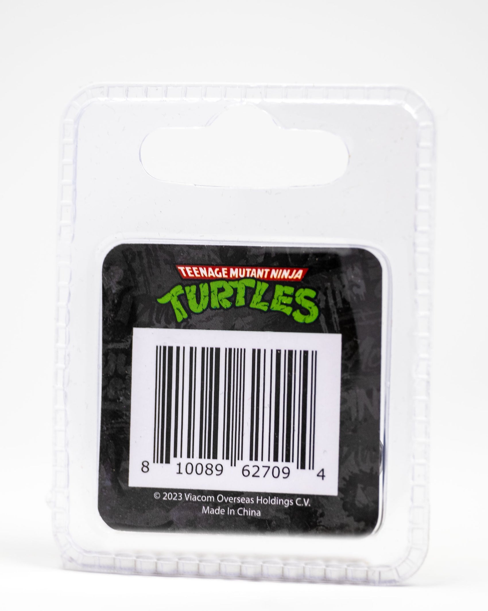 A clear plastic retail package displays the Pins and Aces TMNT - Sewer Cover Ball Marker, with a Teenage Mutant Ninja Turtles logo above the barcode. Text at bottom: ©2023 Viacom Overseas Holdings C.V. Made in China.