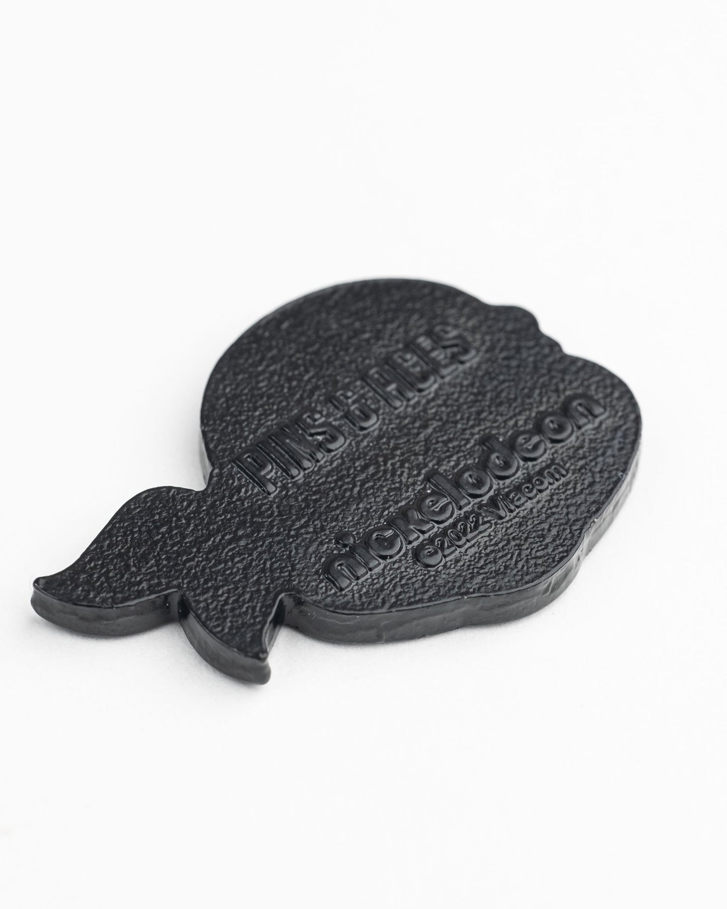 A black, textured rubber patch shaped like Leonardo’s head with embossed Pins and Aces and Nickelodeon logos—perfect as a TMNT - Leonardo Ball Marker from Pins and Aces for your golf game.