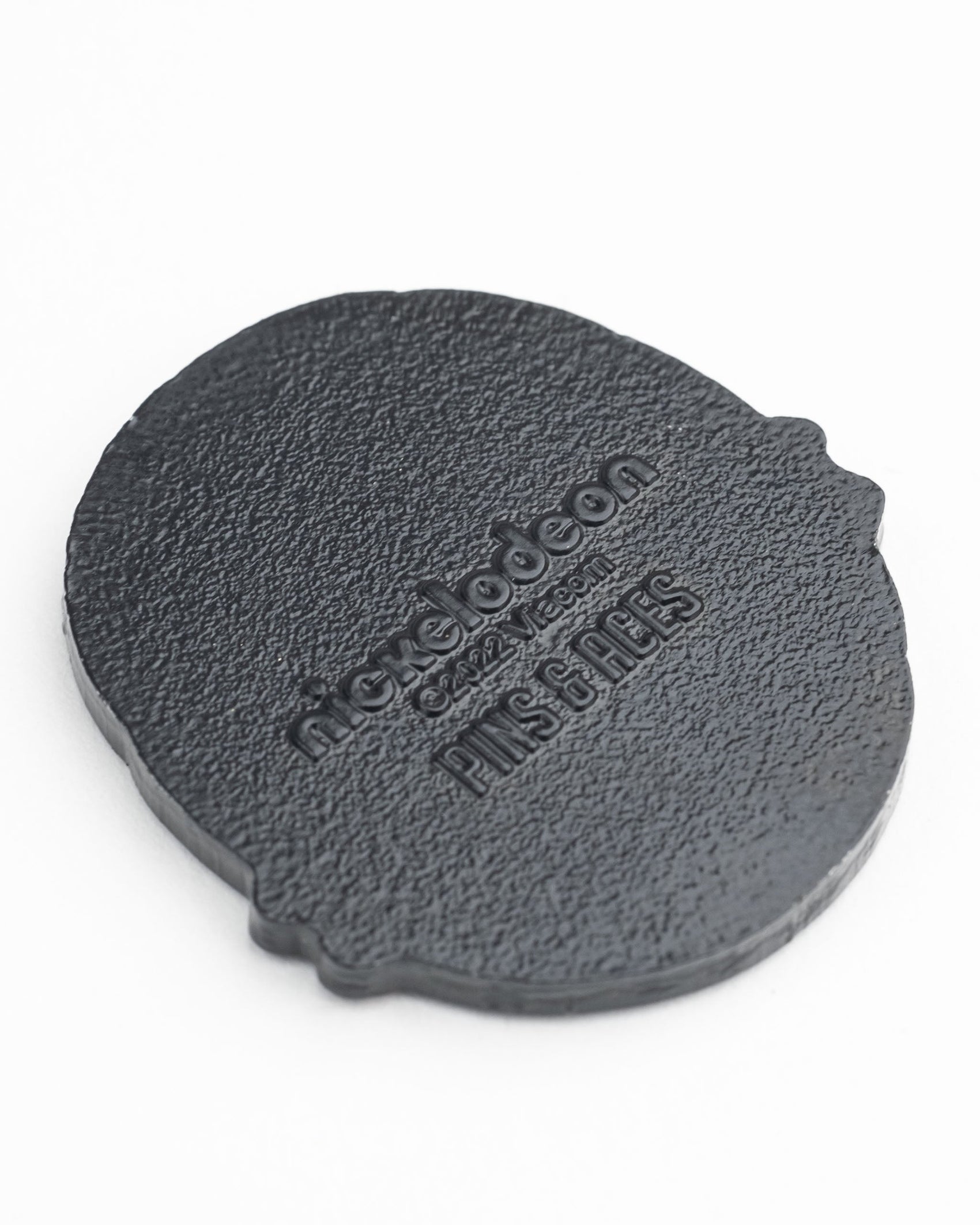 A textured black oval pin backing with embossed Pins and Aces and official branding—perfect for pairing with your TMNT - Shell Shock Ball Marker or other Teenage Mutant Ninja Turtles golf accessories.
