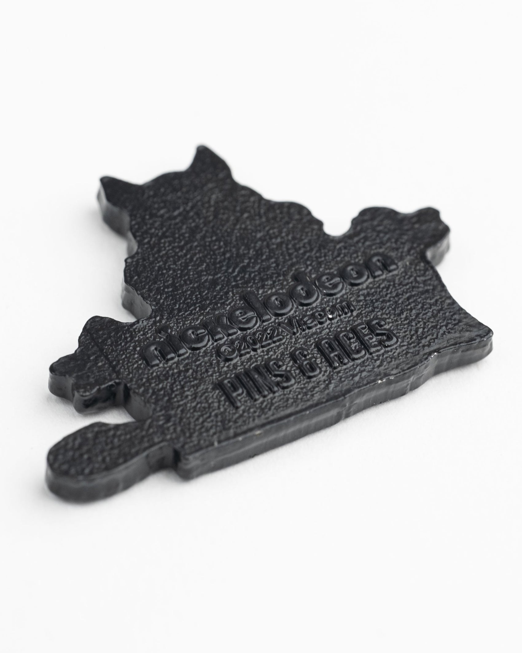 A black, textured TMNT - Splinter Ball Marker pin by Pins and Aces with “Nickelodeon PIN STAGES” raised on it. Great for Teenage Mutant Ninja Turtles fans and golf accessory collectors. Shown on a white background.