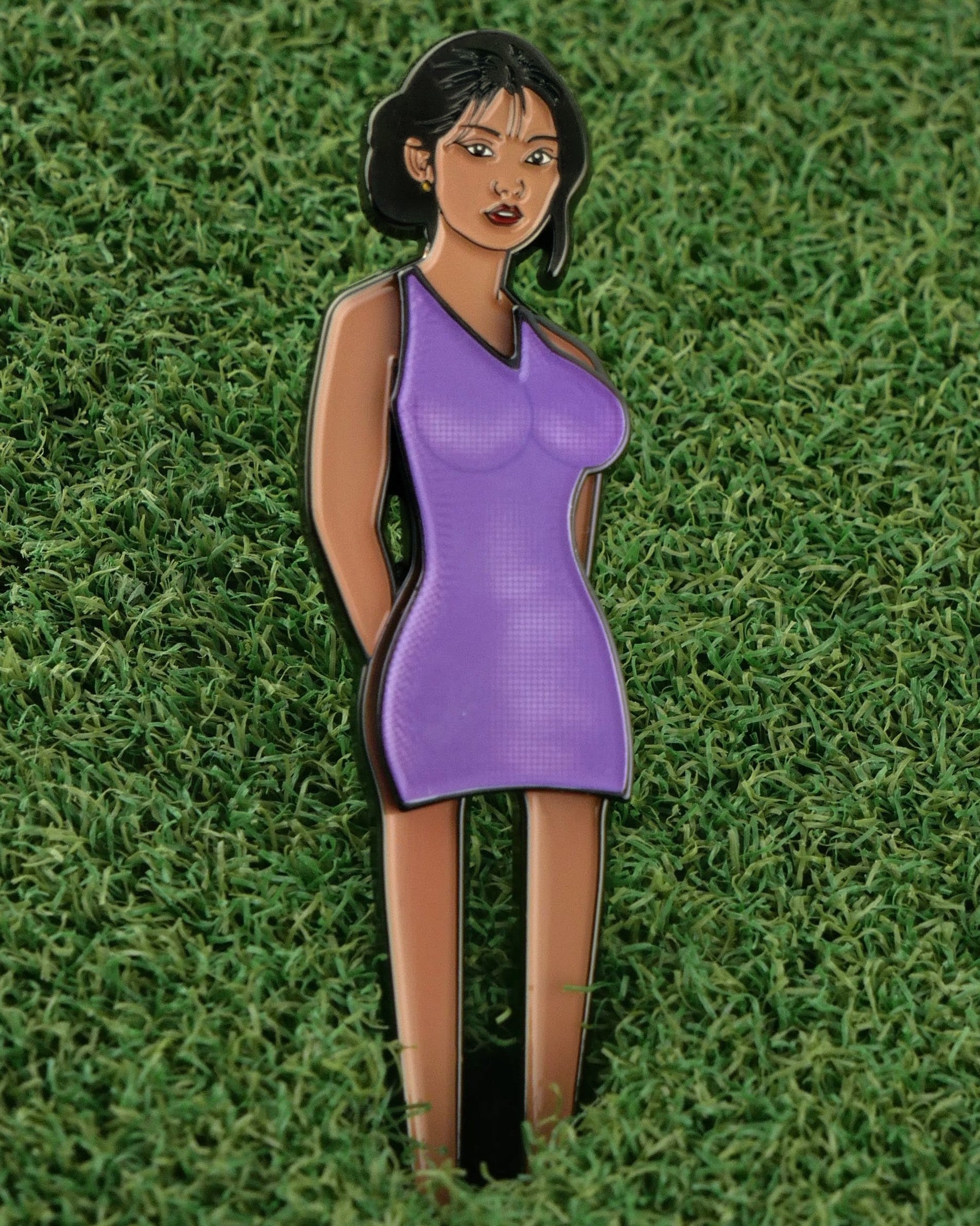 The Thai Lady Boy pin from Ballmarkers.com features an illustrated woman with short black hair in a purple dress, set against a grassy background—ideal as a premium golf ball marker or Lady Boy divot tool accessory.