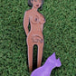 The Thai Lady Boy by Ballmarkers from Logie Joes is an illustrated pin of a nude woman with visible tattoos and a removable purple dress, perfect as a unique golf accessory or ball marker for your collection.