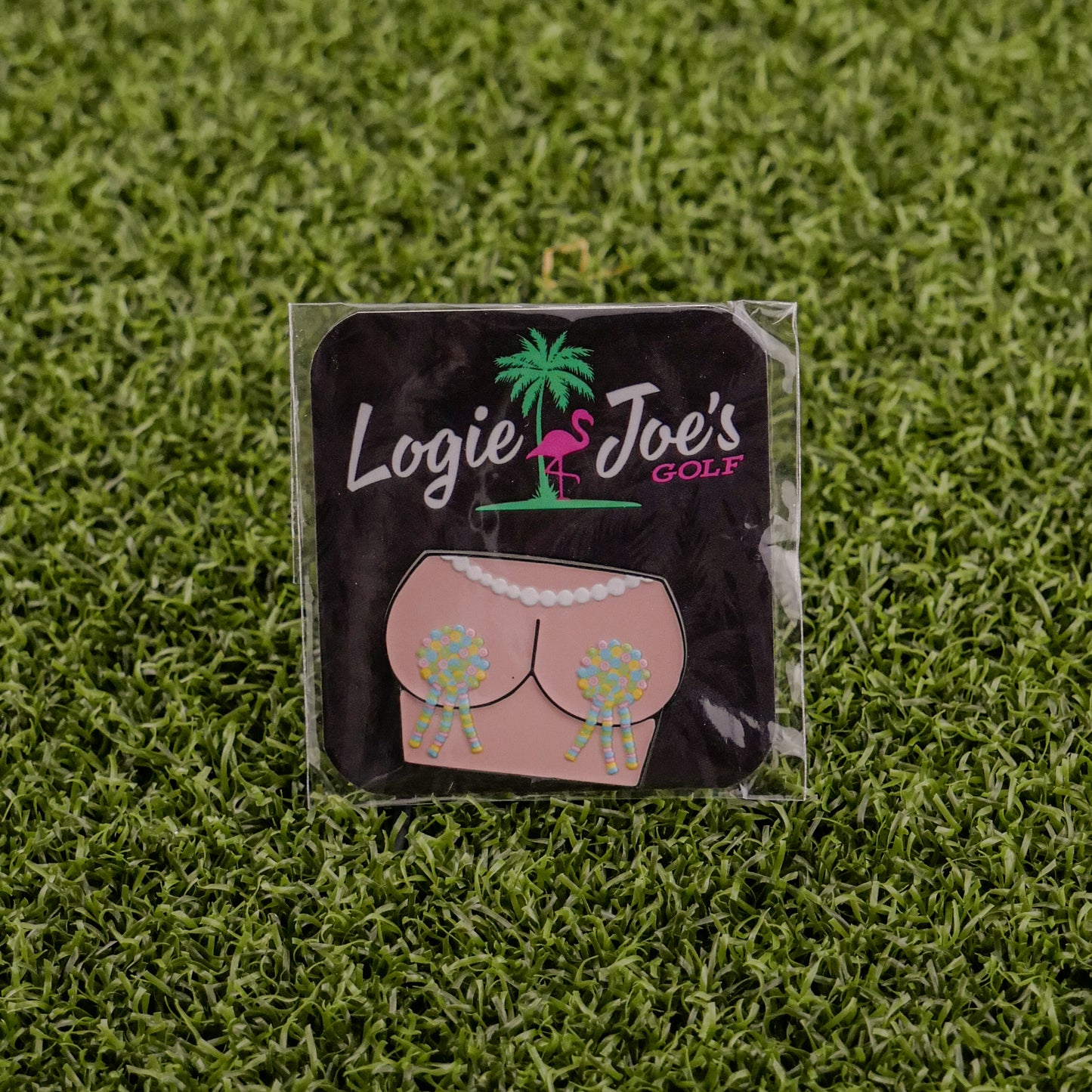 A square “Titty Tassles” sticker from Logie Joe’s Golf features a flamingo, palm tree, and cartoon bikini bottom with golf ball tassels—great as a quirky golf ball marker or fun gift for golf fans.