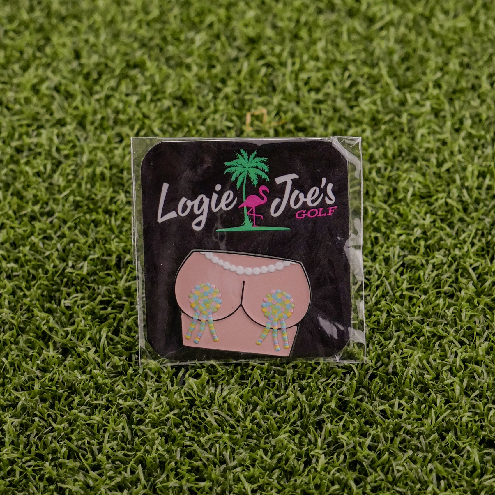 A square “Titty Tassles” sticker from Logie Joe’s Golf features a flamingo, palm tree, and cartoon bikini bottom with golf ball tassels—great as a quirky golf ball marker or fun gift for golf fans.