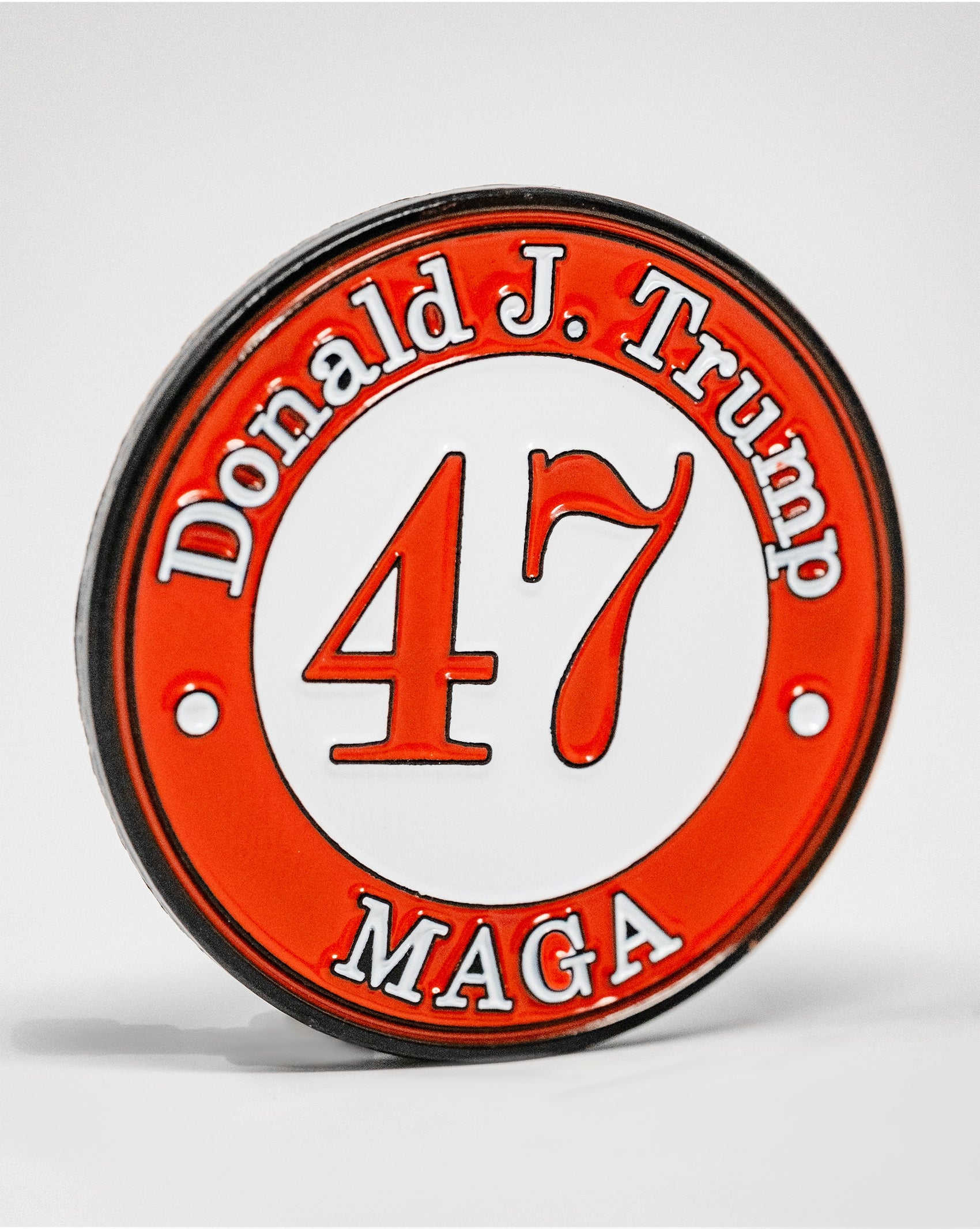 The Pins and Aces 47 Ball Marker is a limited edition, circular badge with a red border, "Donald J. Trump" at the top, "MAGA" at the bottom, and a bold 47 in the center—ideal as a Trump-themed golf ball marker.