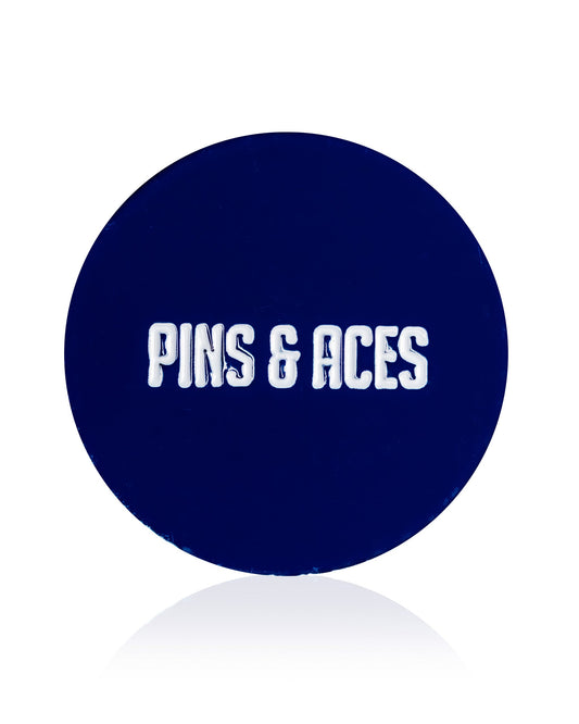 A dark blue circular "USA Soccer Ball - Ball Marker" by Pins and Aces, featuring an enamel finish and "PINS AND ACES" in bold white letters at the center.