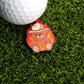 A golf ball on green turf sits next to Logie Joe's Golf "Up In Smoke Ball Marker," which features Smokey the Bear in a ranger hat amid cartoon flames promoting fire prevention.
