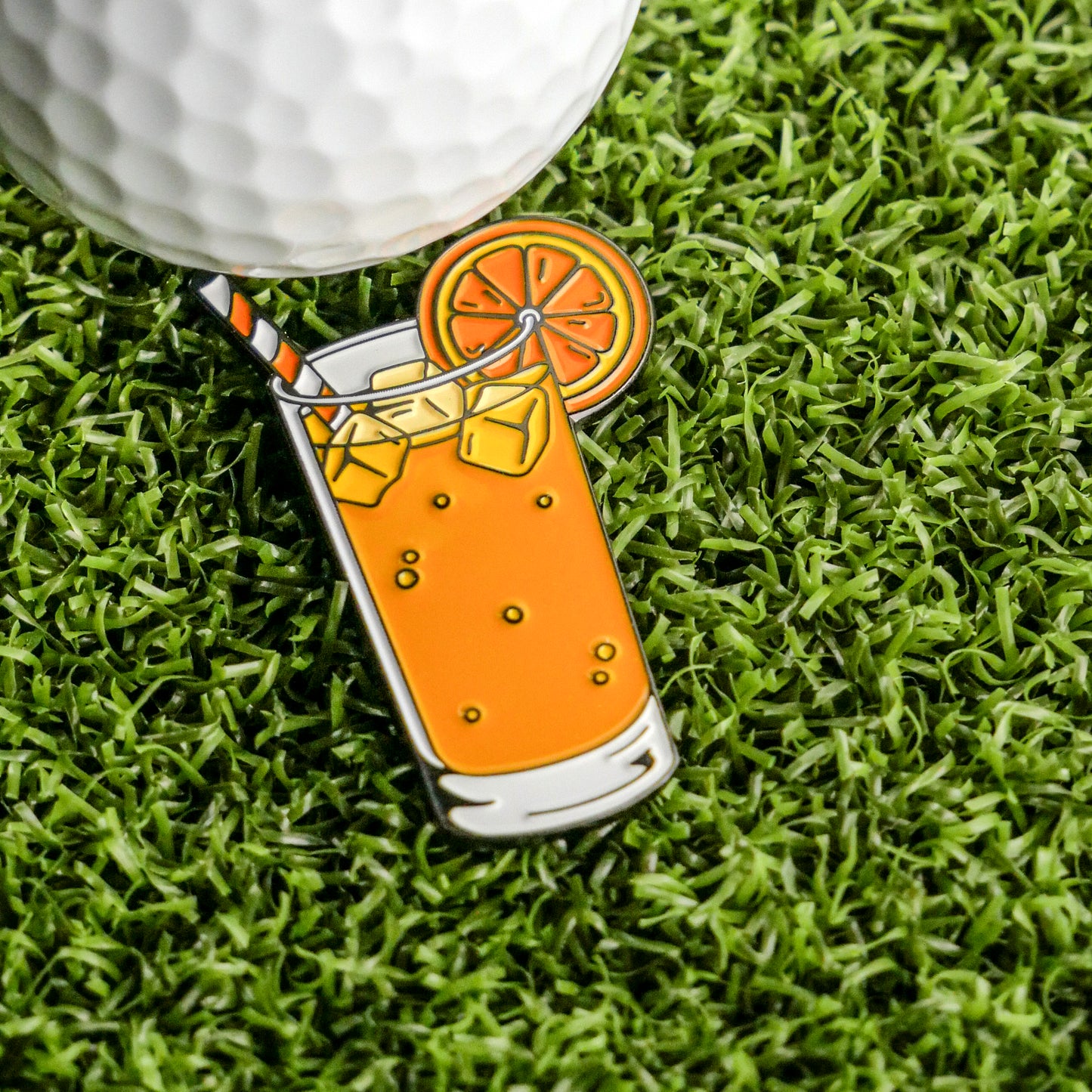 The Vodka Screwdriver Ball Marker by Ballmarkers.com features a glass of screwdriver cocktail design—complete with ice cubes, orange slice, and striped straw—perfect for marking your ball or adding flair to your collection.