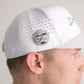 A man in profile wears Doubloon's The Omen Classic Antique, Diamond & Silver Edition—a white perforated baseball cap with a sterling silver, engraved golf ball marker—set against a plain background.