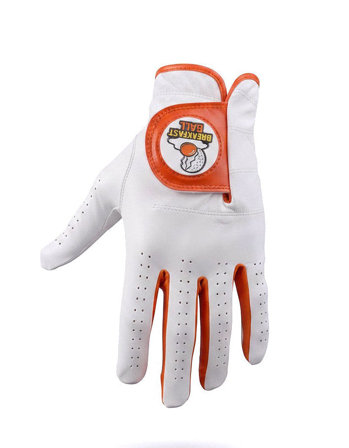 Experience elevated performance and distinctive style with the Breakfast Ball Cabretta Leather Golf Glove from Logie Joe’s Golf. Crafted from premium Cabretta leather in white with vibrant orange trim, this glove features a circular patch on the closure strap with BREAKFAST BALL inscribed above a cracked egg illustration. A magnetic ball marker adds convenience, making it an ideal choice for discerning golfers. Available in left and right hand as well as standard and cadet sizes, this glove is part of