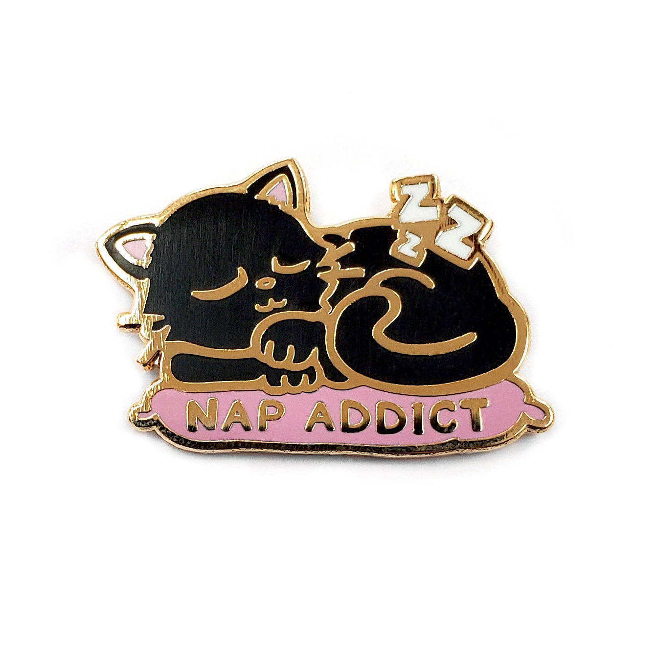 Kolorspun’s Cat Nap Addict Golf Ball Marker features a black cat with closed eyes on a pink cushion labeled NAP ADDICT in gold lettering, accented by Z symbols. This enamel pin is a perfect custom golf gift or unique ball marker.