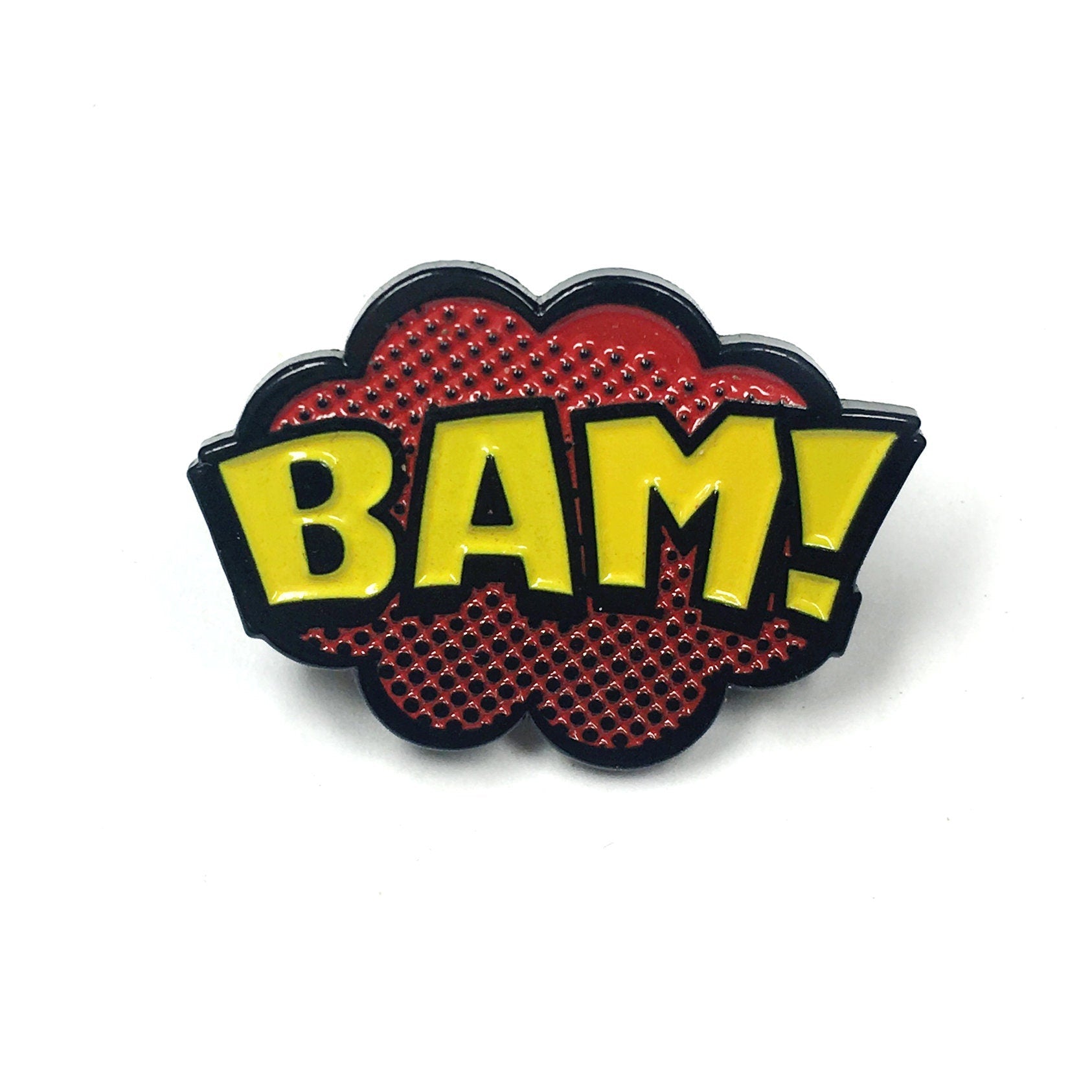 Kolorspun’s Bam Golf Ball Marker features bold yellow "BAM!" lettering with a black outline on a red cloud background with dotted accents—a comic-style, magnetic marker and fun custom gift for golfers.