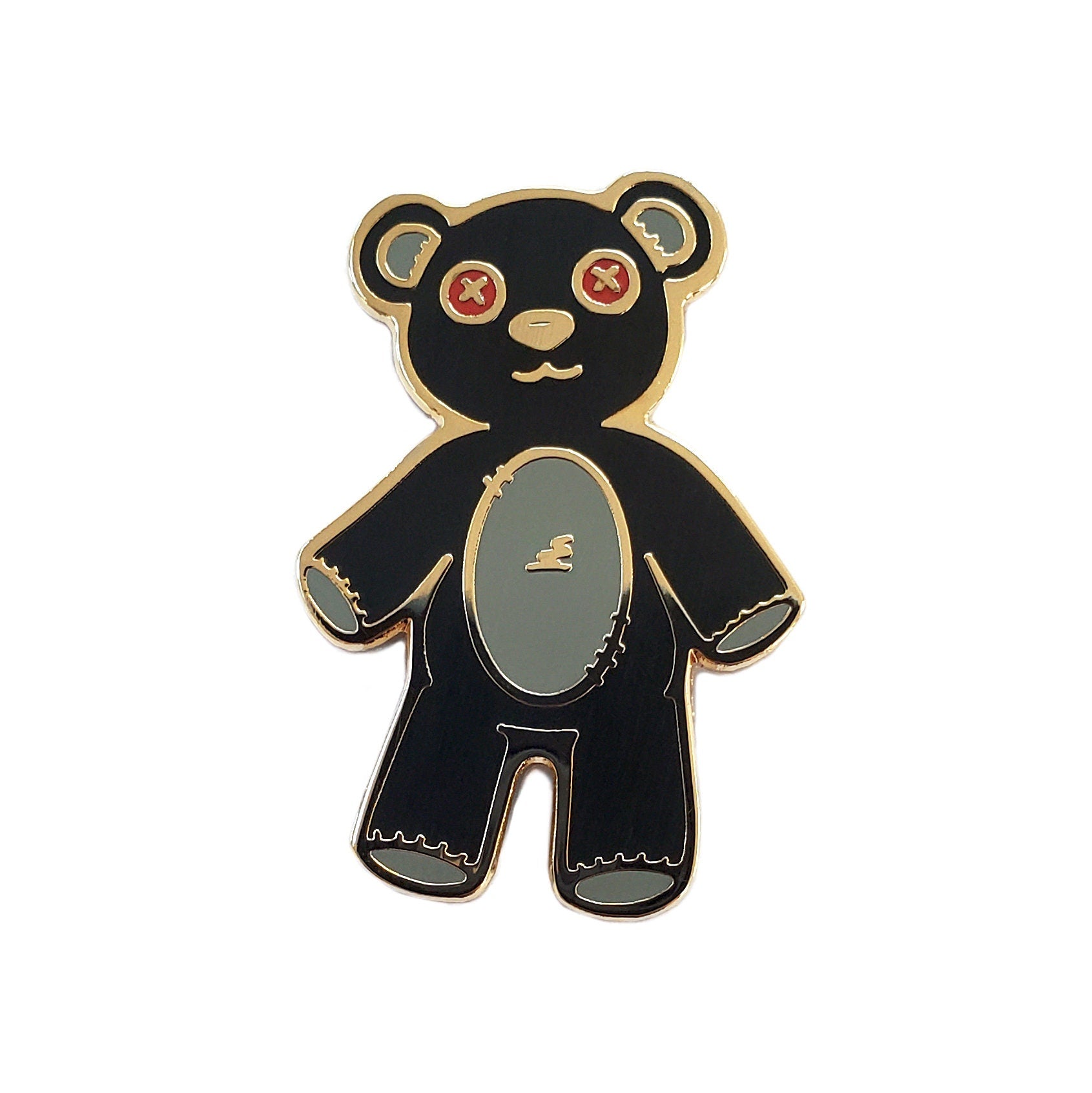 The Kolorspun Teddy Bear Golf Ball Marker features a black bear with red X eyes, a light gray belly, and gold outlines on white. Its magnetic back and unique stitched look make it a cute, quirky golf gift.