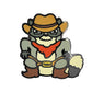 The Kolorspun Cowboy Raccoon Golf Ball Marker features a cartoon raccoon in cowboy hat, bandana, glasses, boots, and "TRASH" belt buckle—ideal as a fun magnetic ball marker or unique custom golf gift.