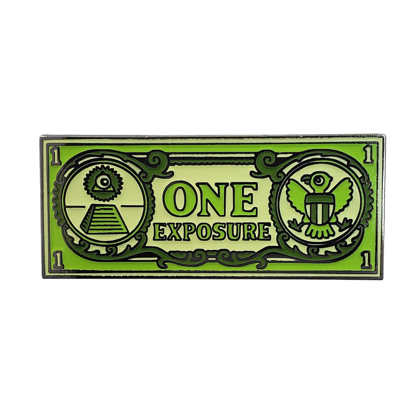 The Kolorspun One Exposure Golf Ball Marker is a rectangular marker styled like a dollar bill, with ONE EXPOSURE in the center, a pyramid and eye on the left, and an eagle on the right—all in green. A unique gift for any golf enthusiast!.