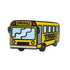 The Kolorspun Struggle Bus Golf Ball Marker features a cartoon yellow bus with "STRUGGLE" above the windshield and on the side, playful blue windows—a quirky gift or fun accessory for any golf game.