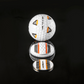 The OnPointGolf.us Two Rail Ball Marker set includes a white golf ball with orange, black, and silver triangular designs, a matching 3D ball marker, and an alignment tool with bold black and orange stripes on a reflective surface.