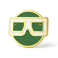 The BLURRD PREMIUM BALL MARKER by BLURRD features a gold and green round design with bold, white-framed glasses on a textured green background—an ideal magnetic golf accessory for your next round.